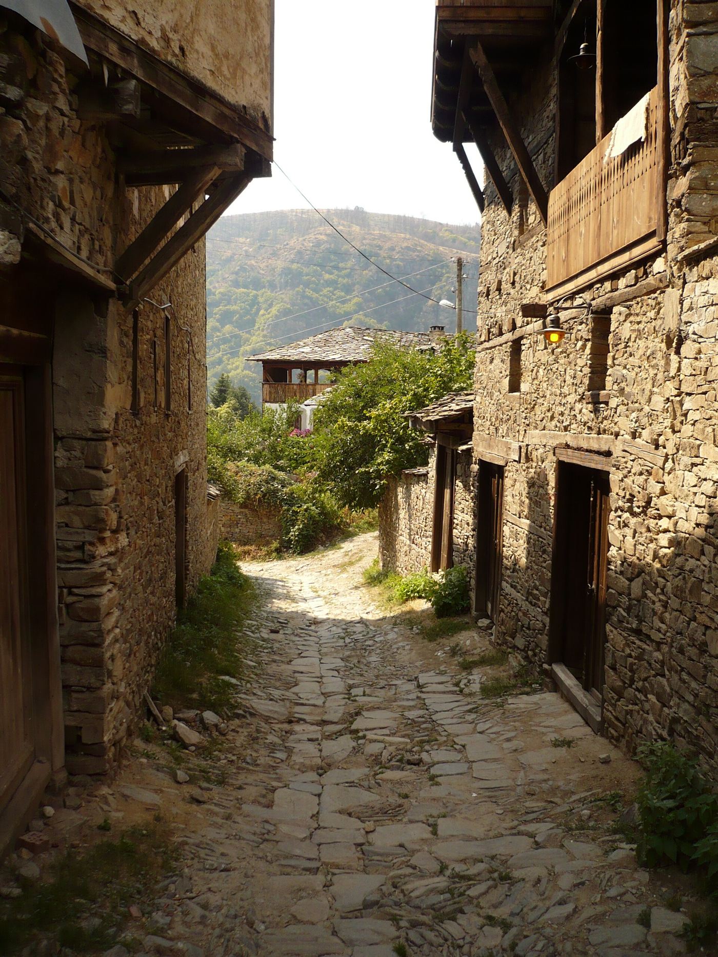 A narrow cobbled street between tall stone houses in Kovachevitsa